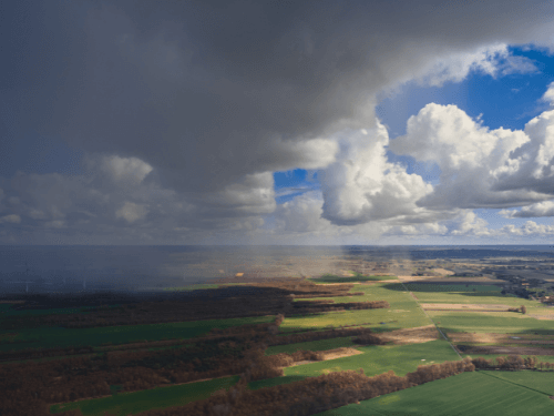 View of fields from above with a cloudy sky.