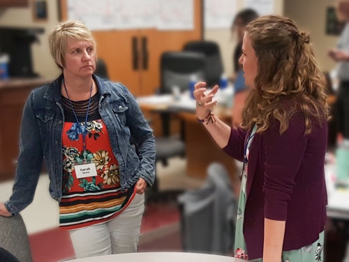 Two women talking during a Professional Development Provider Institute.